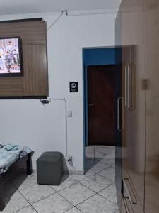 伊塔尼亚恩Hostel do Enzo的一间设有滑动玻璃门和电视的客房