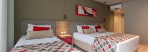 格拉玛多Laghetto Stilo Borges - Apto 403B的一间卧室配有两张带红色枕头的床