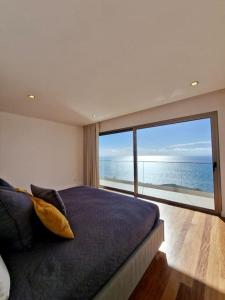 蓬他达维托亚Lê Maison Deluxe Madeira的一间卧室设有一张床,享有海景