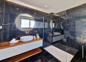 蓬他达维托亚Lê Maison Deluxe Madeira的一间带水槽和镜子的浴室