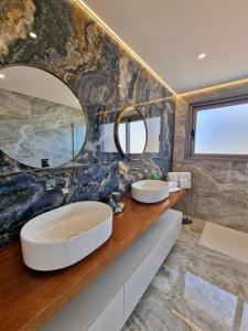 蓬他达维托亚Lê Maison Deluxe Madeira的一间带两个盥洗盆和大镜子的浴室
