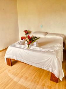 努基Cabañas Iracas del Mar的一张白色的床,上面有一束鲜花