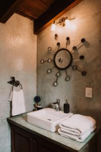 危地马拉安地瓜Bärehuus Boutique Hotel的一间带水槽和墙上时钟的浴室