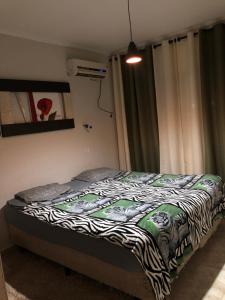 瓜鲁雅Quarto Duplo Costa brava的一间卧室配有一张带斑马纹毯子的床
