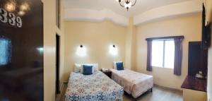 危地马拉塞维利亚酒店的一间卧室设有两张床和窗户。