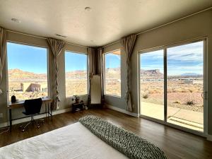 比格沃特Calming Canyon Sanctuary with Grand Mesa Views的一间卧室设有大窗户、一张床和一张书桌