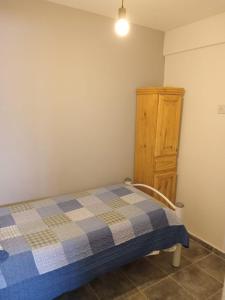 内乌肯La Casita de Nala的一间卧室配有一张床和一个木制橱柜