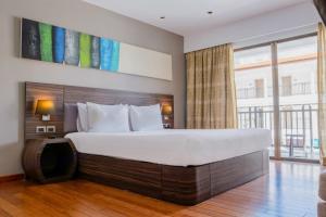 卡伦海滩Holiday Inn Resort Phuket Karon Beach, an IHG Hotel的一间卧室设有一张大床和一个大窗户