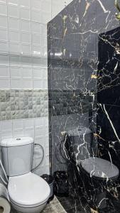 拉巴特Riad Dar Doura的浴室设有白色卫生间和黑色墙壁。