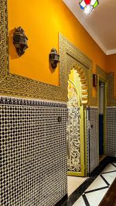 拉巴特Riad Dar Doura的浴室设有黄色和白色的瓷砖墙