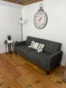 马塞纳Sleep at Simplicity的客厅的沙发,墙上有时钟