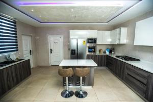 阿克拉Elegant and Cosy Four Bedroom Home in Accra的厨房配有桌子和冰箱