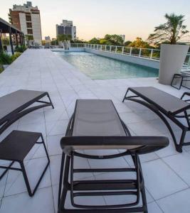亚松森Hermoso departamento en Skytower的一个带两张桌子和椅子的庭院,毗邻一个游泳池