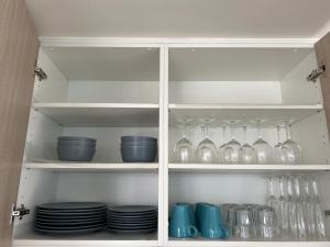 墨尔本温斯顿码头公寓的装满玻璃杯、盘子和碗的橱柜