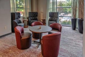 赫恩登赫恩登杜勒斯机场万怡酒店的配有椅子、桌子和桌椅的房间