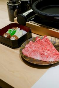 二世古MUWA NISEKO的盘子上的肉和一盒糕点