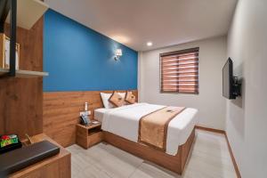 边和Bcons PS Hotel and Apartment- Newly Opened Hotel的一间卧室设有一张床和蓝色的墙壁