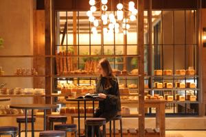 京都NOHGA HOTEL KIYOMIZU KYOTO的坐在面包店桌子上的女人