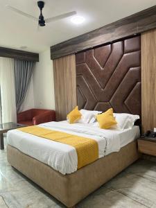 NizāmābādHotel krishna的一间卧室配有一张大床和木制床头板