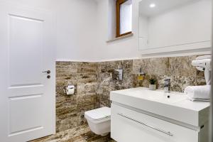 阿拉德Sika Royal Central Apartment的白色的浴室设有卫生间和水槽。