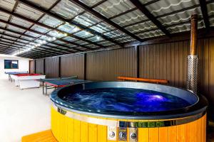 巴亚德菲耶尔Agropensiunea DarDen的一个带乒乓球桌的房间的大型热水浴缸