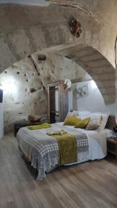 马泰拉Il Geco的卧室配有一张石墙内的大床