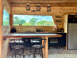 利富岛Ô Naturel Lodge Lifou的厨房配有带3把吧台凳的吧台
