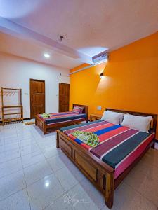 达瓦拉维Yoma Wild Hotel的黄色墙壁客房的两张床