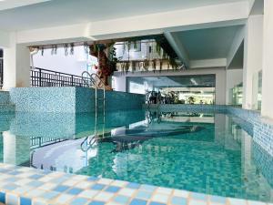 万象Vientiane city center modern apartment的蓝色瓷砖建筑中的游泳池