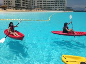 拉塞雷纳Departamento Resort Laguna del Mar的两人在游泳池里划皮艇