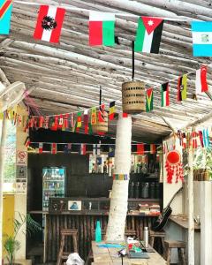 安君纳THE MUSAFIR HOSTEL的餐厅悬挂着悬挂在木天花板上的旗帜
