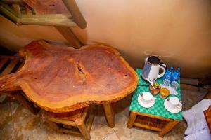 VoiBoma Simba Safari Lodge的一张桌子,上面有一张大木桌和茶具