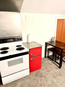 底特律Two Bedroom Villa Studio with fireplace & Living room的厨房配有白色炉灶和红色橱柜。