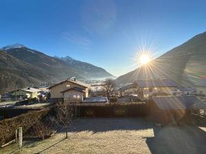 上韦拉赫Bergzauber Obervellach im Mölltal的阳光照耀着一个山 ⁇ 的村庄