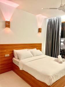 马米基里Vilu Residence的一间卧室配有一张带白色床单的大床
