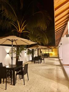 马米基里Vilu Residence的一间带桌椅和遮阳伞的餐厅