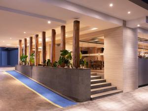 日惹Aveta Hotel Malioboro的大堂设有楼梯和盆栽植物