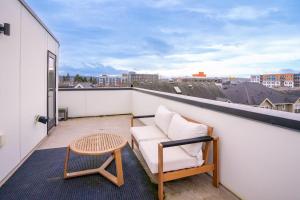 西雅图Ballard's Pet-Friendly Mid Century Home + Rooftop Deck的阳台配有沙发和屋顶桌子。
