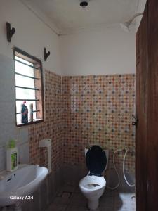 乌昆达Hideout的浴室配有卫生间、盥洗盆和浴缸。