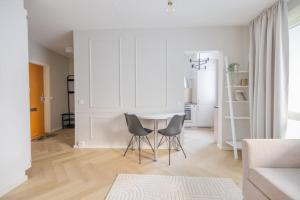 万塔30m2 studio - 500m from train station to Airport and Helsinki city centre的客厅配有桌子和两把椅子