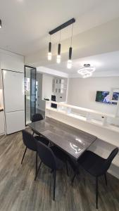 基希讷乌Аэропорт Апартаменты 24&24的一间设有玻璃桌和黑色椅子的用餐室