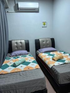 怡保BOTANI LOFT HOMESTAY的两张睡床彼此相邻,位于一个房间里