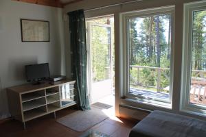 EdsbrukGärdsholmens Skärgårdshemman "Eken"的客厅设有2个大窗户和电视