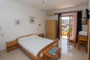 波帝卡Thaleia view的一间卧室配有一张床、一张书桌和一个窗户。