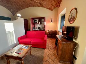 蒙卡列里乐塞尔套房公寓酒店的客厅配有红色沙发和电视