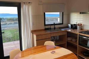 埃尔卡拉法特Cabaña Patagonia的厨房配有桌子和带窗户的柜台