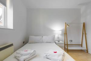 伦敦2-BR London Oasis in Woolwich的卧室配有白色床和毛巾