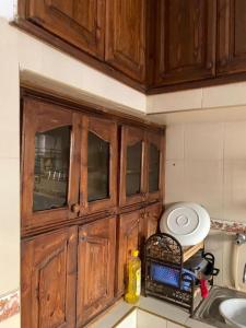 胡里卜盖Furnished apartment的一个带木制橱柜和水槽的厨房