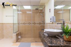 迪拜HOMESTAR, Deluxe Hostel - JBR - Walk To Beach, Metro Station的一间带水槽和玻璃淋浴的浴室