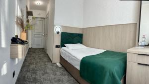伊万诺-弗兰科夫斯克Prykarpattya的一间卧室配有一张带绿色床头板的床